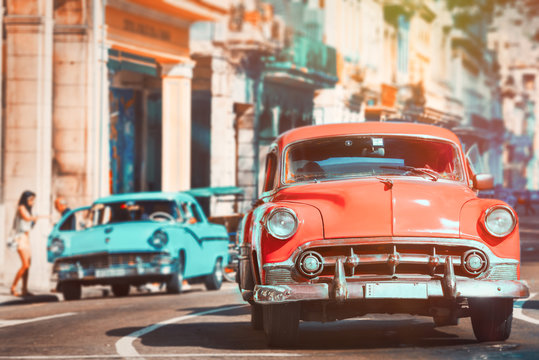 Fototapeta Urban scene with antique cars in Havana