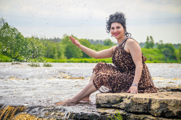 Woman on the waterfalls. Little waterfall. Camping. . Young woman. Woman in a dress.
