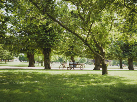 Older couple sitting in park on bench with bicycles Copenhagen city Denmark