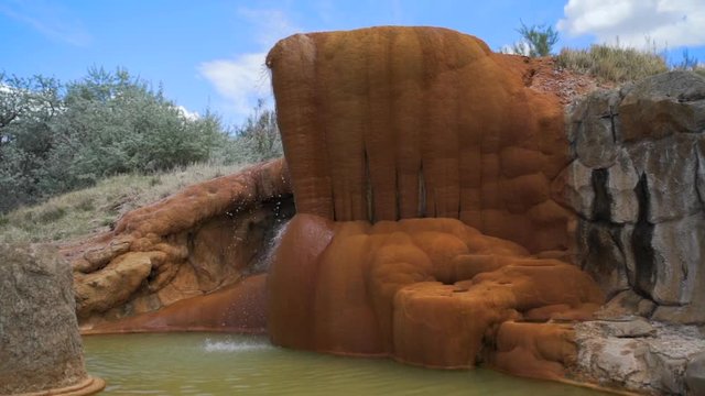 Slow Motion Water Falling Over Large Orange Rock in Desert at Mystic Hot Springs - Monroe, Utah