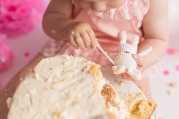 first cake. pink cake. the child takes the cake with his hand. hand in pastry cream. children's holiday