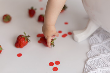 the child is holding strawberries. strawberry. child's hand