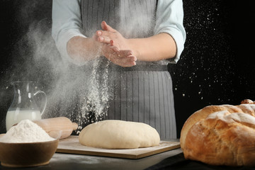 Female baker preparing bread dough at kitchen table