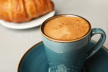 Cup of tasty aromatic coffee for breakfast on grey table, closeup