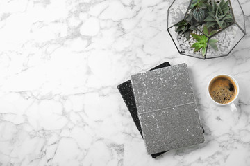 Flat lay composition with notebooks, coffee and succulents on marble table. Space for text