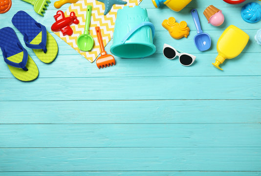 Flat Lay Composition With Beach Toys On Color Wooden Background. Space For Text