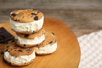 Sweet delicious ice cream cookie sandwiches on table, space for text
