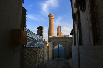 中央アジア　シルクロードの旅　ウズベキスタン　ブハラ　路地と夕陽に映えるカラーン・ミナレットとモスク