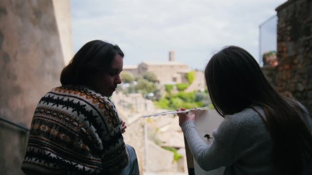 Two women sitting by the stairs and engaged in creativity