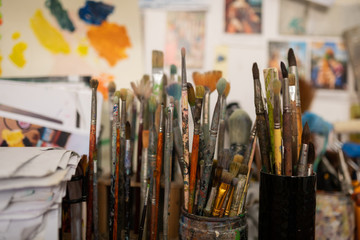 Different think and thick painting brushes standing in workshop