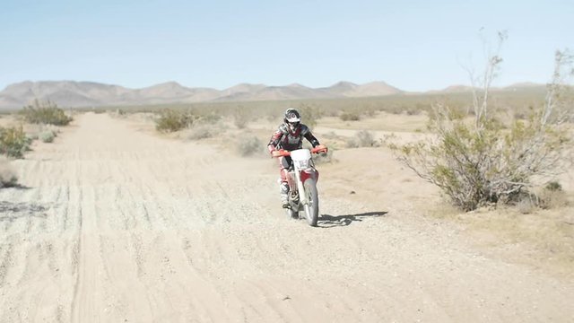 SLOW MOTION: A dirt biker rides his CRF Honda through the desert over a whoop section.