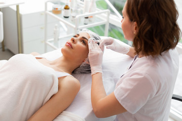 Top view of a beautiful nice woman receiving injections