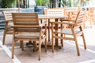 Fototapeta na wymiar Set of wooden chairs and circular table in outdoor cafe at hotel area.