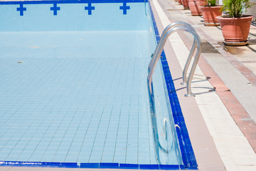 Empty dry swimming pool preparing for cleaning.