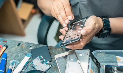 Close-up Of technician's hand showing process of repair and fix cell phone.