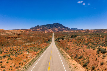 Aerial drone photo - A highway leads into the Henry Mountains in the Utah desert.