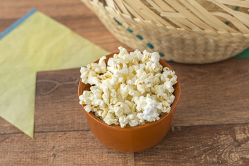 Ceramic bowl with popcorn on gray background