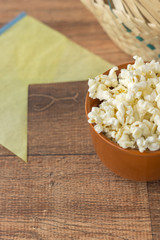 Ceramic bowl with popcorn on gray background
