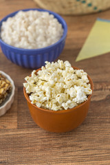 Ceramic bowl with popcorn on gray background
