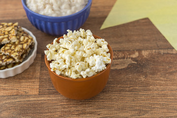 Ceramic bowl with popcorn on gray background