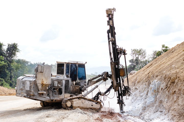 Rock driller on road comnstruction. Drilling rock in the works of creating a road.