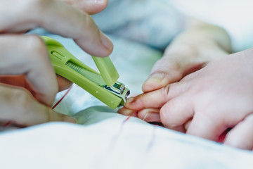 Mother cut baby's finger nails