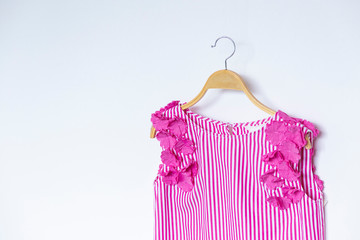 Pink lace with blouse is clothes hanging on white background.