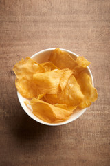 Baked potato chip on wood background