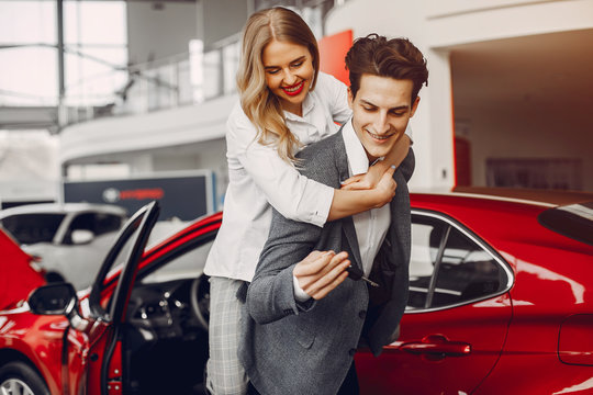 Couple buying the car. Pair in a car salon. Husband with vife choose the automobile