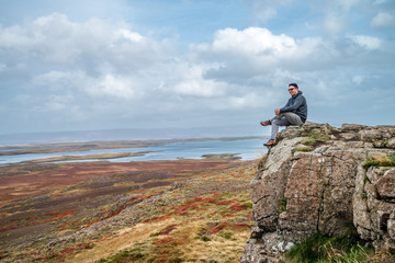 A traveler sitting on the cliff and feeling be happy with his successful. The landscape photo taken from west coastline in autumn of Iceland. - 272740650
