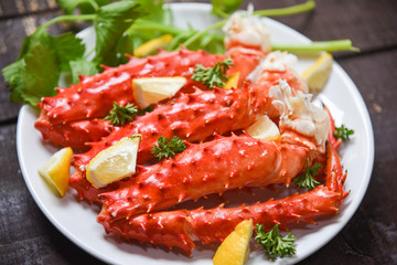 Alaskan King Crab Legs cooked seafood with lemon spices on white plate in the wooden table - red crab hokkaido © Bigc Studio