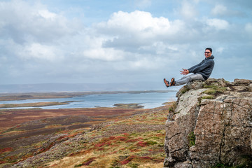 A traveler sitting on the cliff and feeling be happy with his successful. The landscape photo taken from west coastline in autumn of Iceland. - 272740682