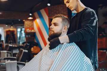 Man with a beard. Hairdresser with a client.