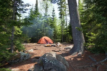 Fotobehang Camping met oranje tent en vuur in de wildernis van Noord-Minnesota © Daniel Thornberg