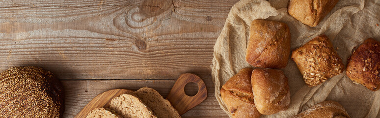 top view of fresh bread and buns on wooden rustic table, panoramic shot © LIGHTFIELD STUDIOS