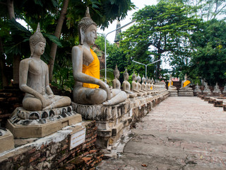 Ancient statues of meditating buddha sitting, at Wat Yai Chaimongkol in Ayutthaya, Thailand