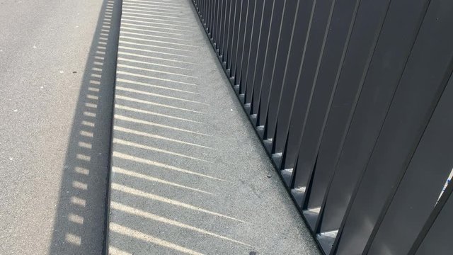 A rail with shadow and sun.