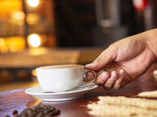 Human hand holding coffee cup in cafe shop