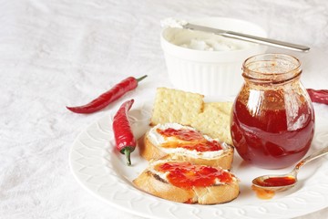 chili jam from chili pepper and paprika. fried toasts, soft (goat) cheese and chili jam. on a light...