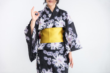 浴衣を着た30代のきれいな女性が白背景で手で丸を作って立っている