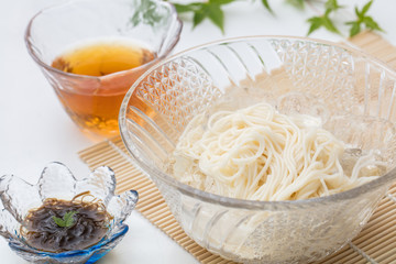 白背景でガラスのお皿に入った冷えたそうめん