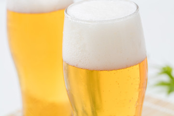 白背景のグラスに注がれたビール