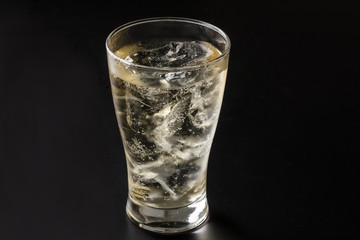 黒背景でグラスにハイボールを注ぐ