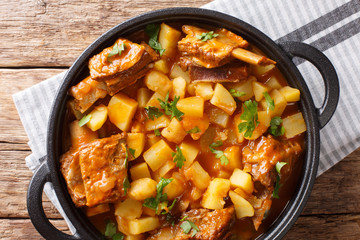 Homemade stew of short beef ribs with potatoes in a spicy sauce closeup in a pot. Horizontal top view