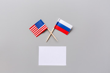 Creative top view flat lay of USA and Russia flags, mockup and copy space on gray background in...