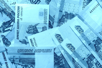 Fototapeta premium Different bills of Russian rubles close up. Money background blue color toned