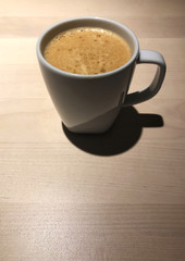 top view of Black coffee in white cup on the wooden table with cafe light. Copy space