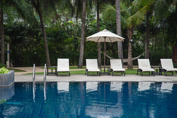 Beach chairs and umbrella beside swimming pool