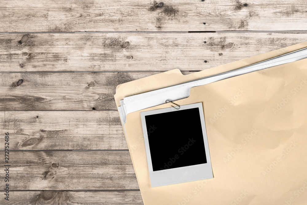 Poster file folder with documents and blank polaroid