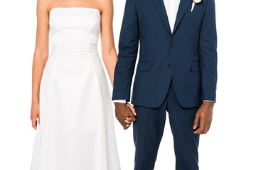 cropped view of african american bride and bridegroom holding hands while standing isolated on white